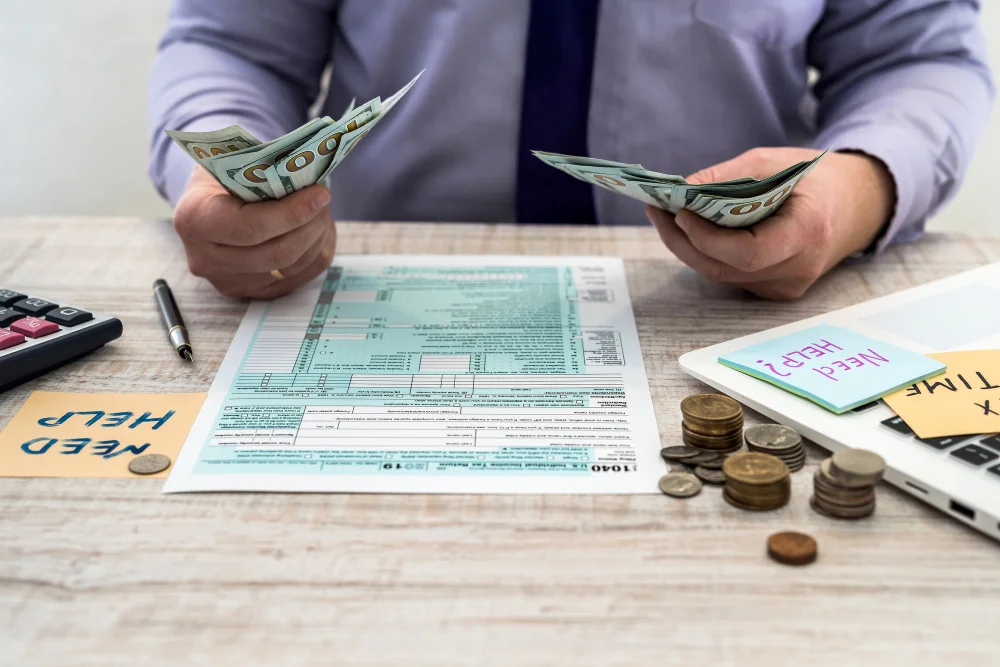 businessman-counts-dollars-fills-out-us-1040-individual-tax-form